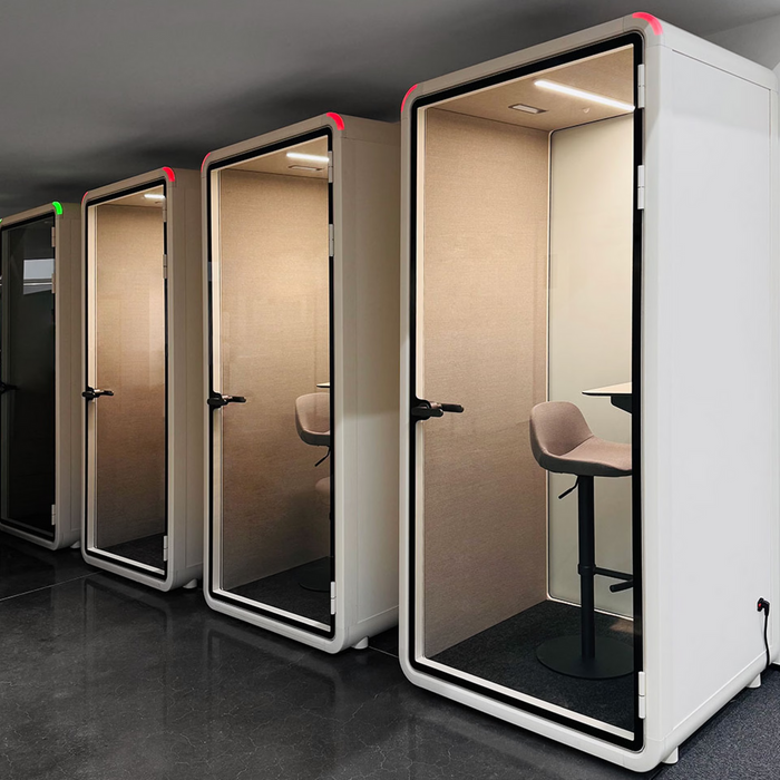 Acoustic office booth beside a desk run
